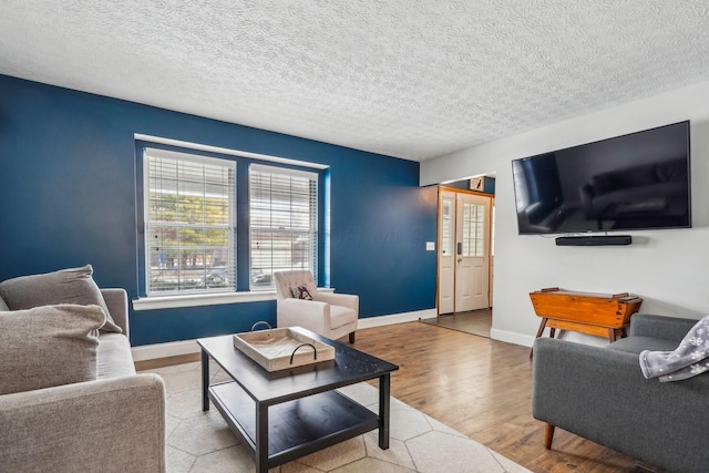 living room with a textured ceiling and light hardwood / wood-style flooring