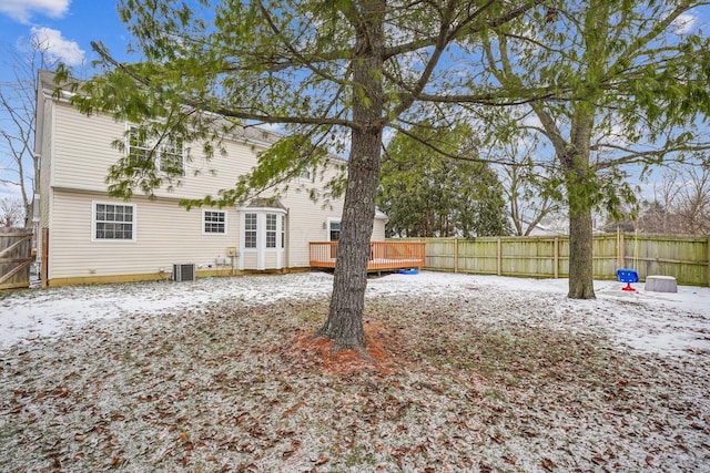 snowy yard featuring a deck and central air condition unit