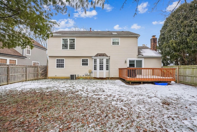 snow covered house with a wooden deck