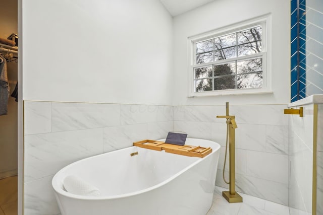 bathroom with a bathing tub and tile walls