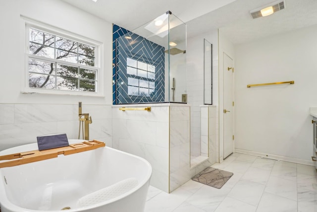 bathroom featuring independent shower and bath, sink, and tile walls