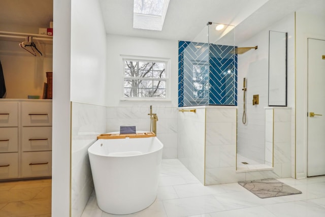 bathroom with tile walls, a skylight, and independent shower and bath