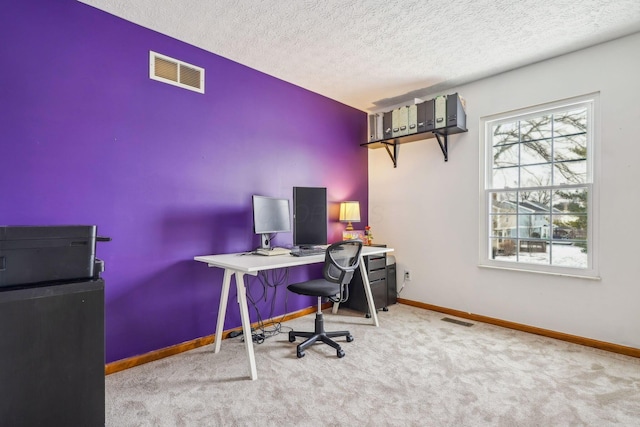 office space featuring light carpet and a textured ceiling