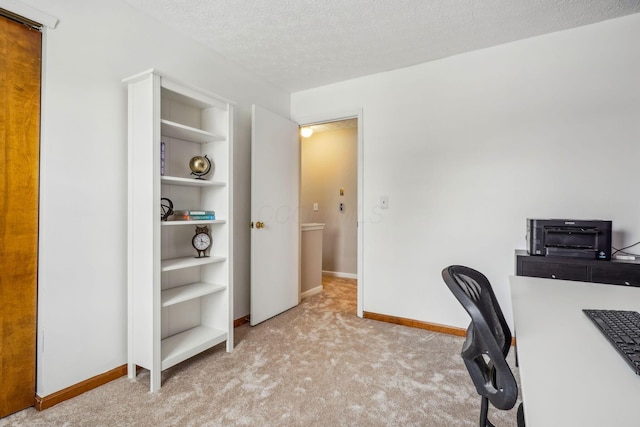 carpeted home office featuring built in shelves and a textured ceiling