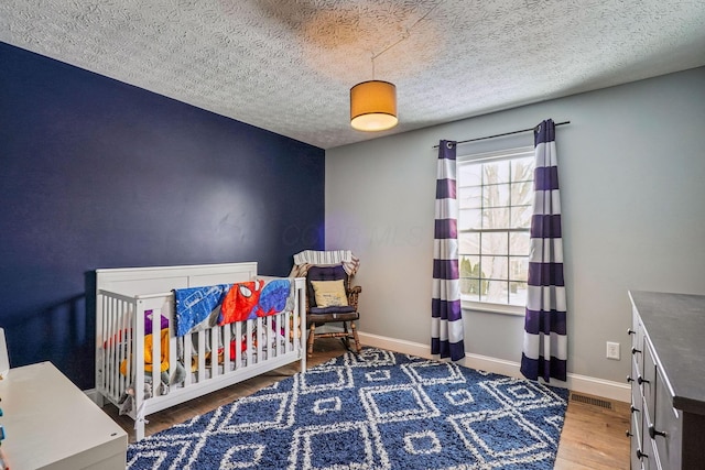 bedroom featuring hardwood / wood-style flooring and a textured ceiling