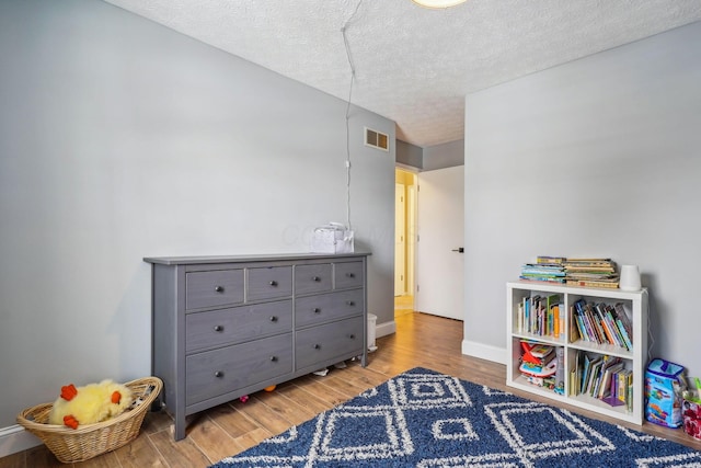 playroom featuring hardwood / wood-style flooring and a textured ceiling