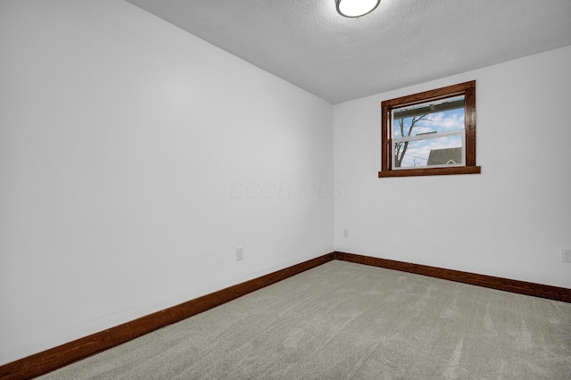 spare room featuring carpet floors and a textured ceiling