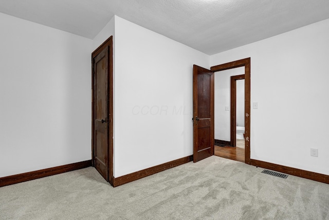 unfurnished bedroom featuring light carpet