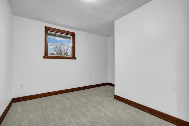 carpeted spare room with a textured ceiling