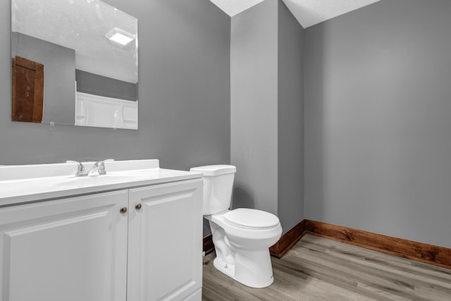 bathroom featuring vanity, a textured ceiling, wood-type flooring, and toilet