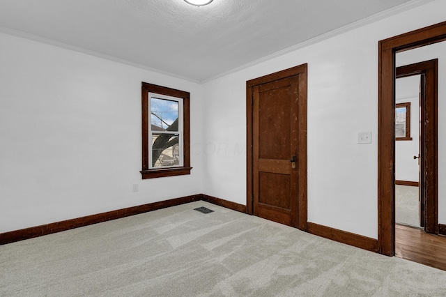 carpeted spare room featuring crown molding