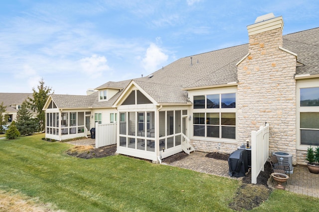 back of house with a lawn, a sunroom, stone siding, roof with shingles, and cooling unit