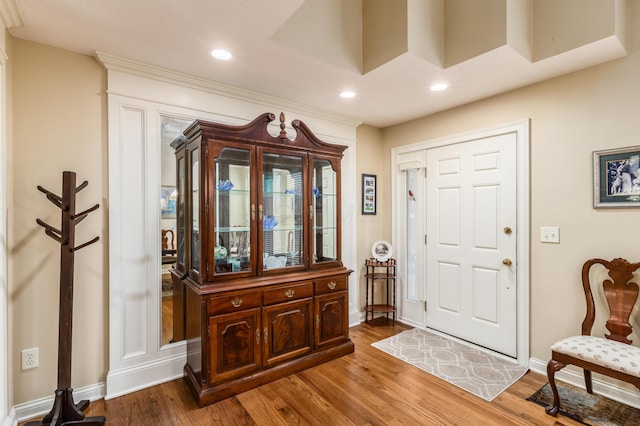 foyer entrance featuring baseboards, wood finished floors, and recessed lighting