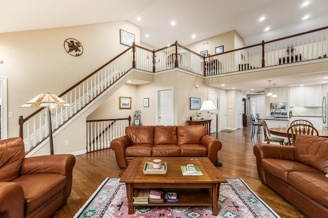 living room with high vaulted ceiling, recessed lighting, and wood finished floors