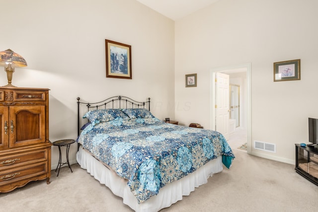 bedroom with baseboards, visible vents, and light colored carpet