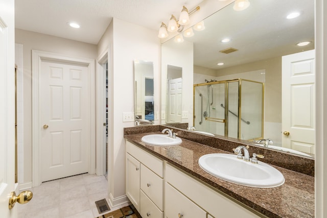 ensuite bathroom featuring connected bathroom, a stall shower, visible vents, and a sink