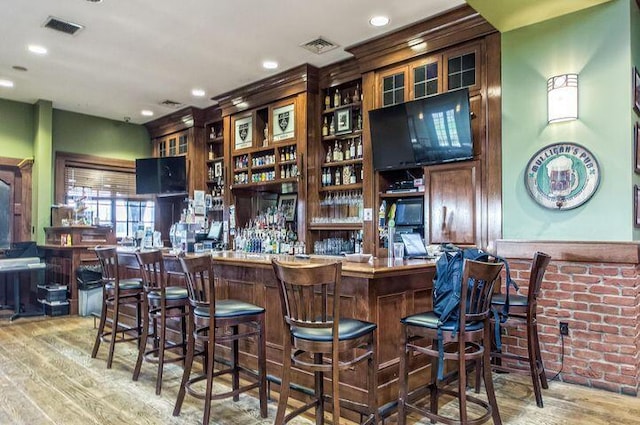 bar featuring a dry bar, visible vents, wood finished floors, and recessed lighting