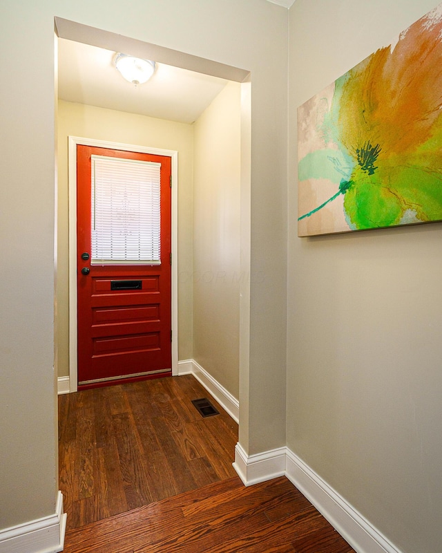 doorway to outside featuring dark wood-style floors, visible vents, and baseboards