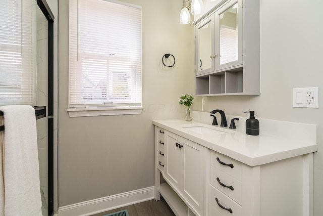 bathroom with baseboards, wood finished floors, and vanity