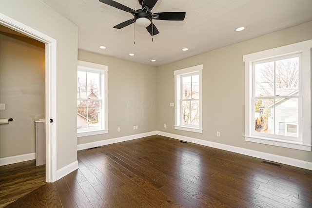 unfurnished bedroom featuring dark wood-style floors, multiple windows, and baseboards