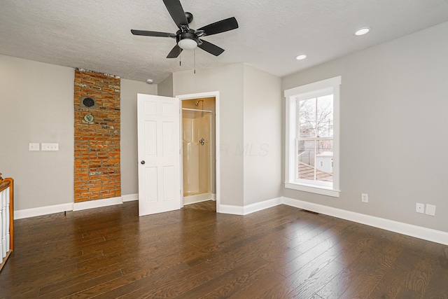 unfurnished bedroom with dark wood finished floors, a textured ceiling, and baseboards