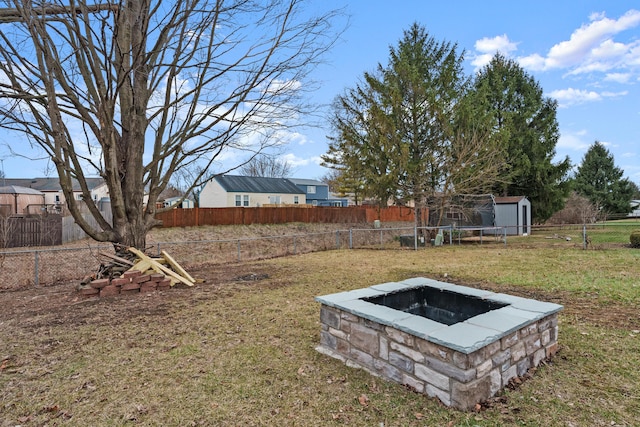 view of yard featuring a storage unit and a fire pit