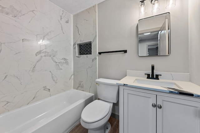 full bathroom featuring vanity, tiled shower / bath, and toilet