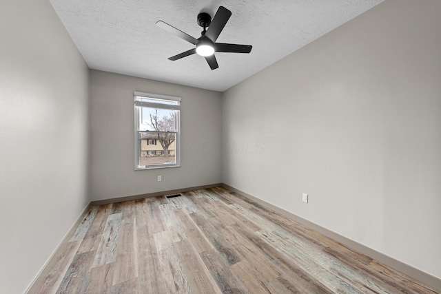 unfurnished room with ceiling fan, a textured ceiling, and light hardwood / wood-style flooring