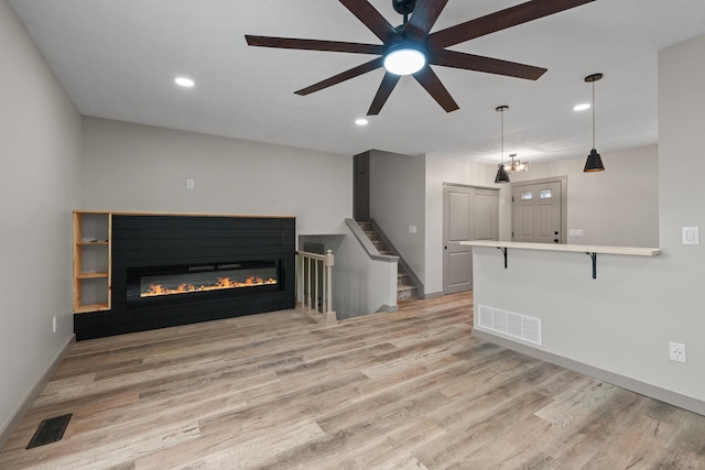 unfurnished living room with ceiling fan and light hardwood / wood-style flooring