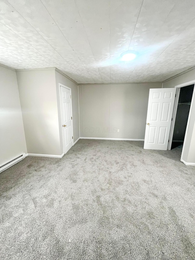 carpeted empty room featuring baseboard heating