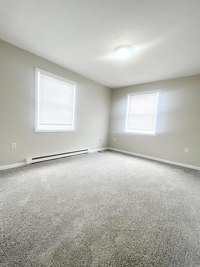 carpeted empty room with baseboard heating