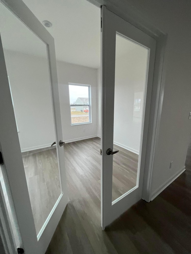 doorway to outside featuring baseboards and wood finished floors