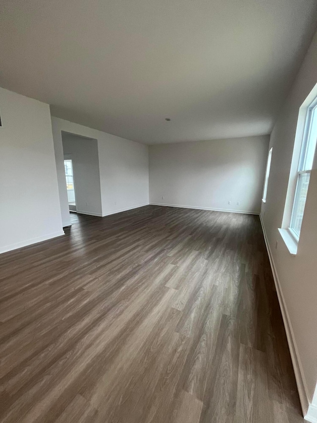 interior space with baseboards and dark wood-style flooring