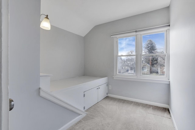 bedroom featuring lofted ceiling, baseboards, and light colored carpet