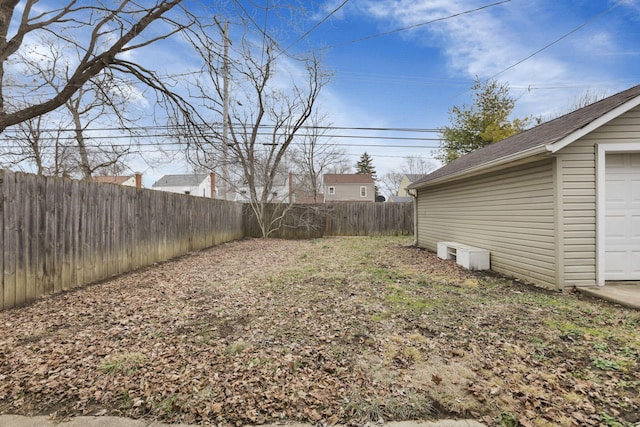 view of yard featuring a garage, an outdoor structure, and a fenced backyard