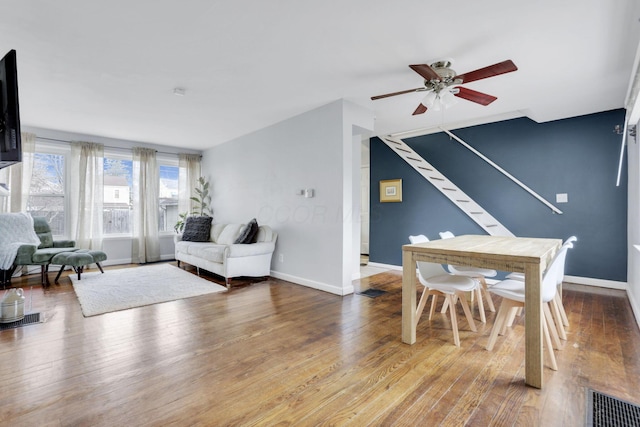 living area featuring stairs, hardwood / wood-style flooring, and baseboards