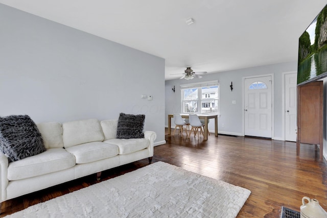 living area with a ceiling fan, visible vents, baseboards, and wood finished floors