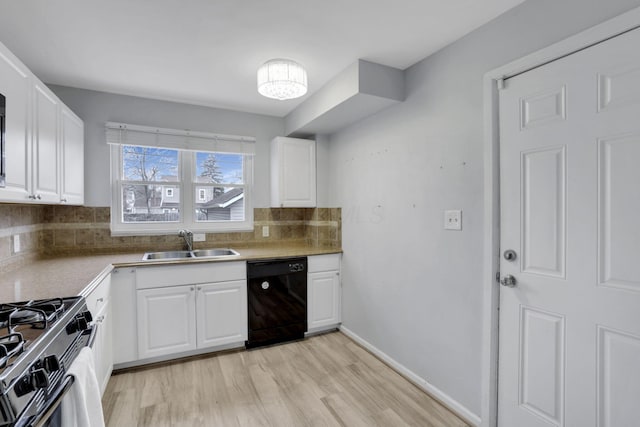 kitchen featuring black dishwasher, a sink, and white cabinetry