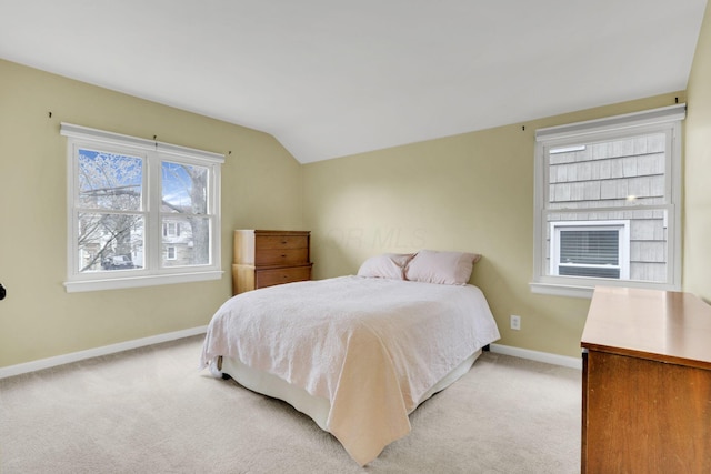 bedroom with light carpet, vaulted ceiling, and baseboards