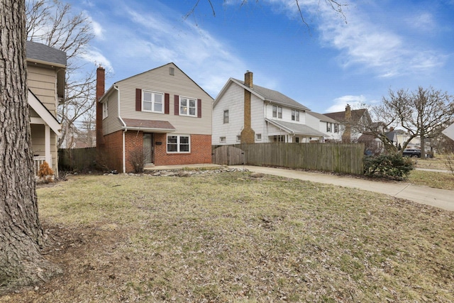 exterior space with a yard, fence, and brick siding