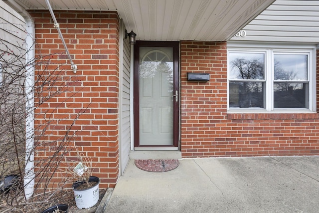 entrance to property featuring brick siding