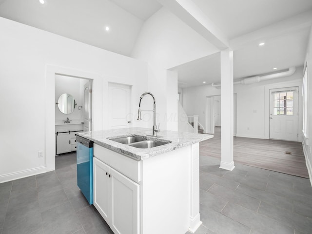 kitchen with sink, light stone counters, stainless steel dishwasher, an island with sink, and white cabinets