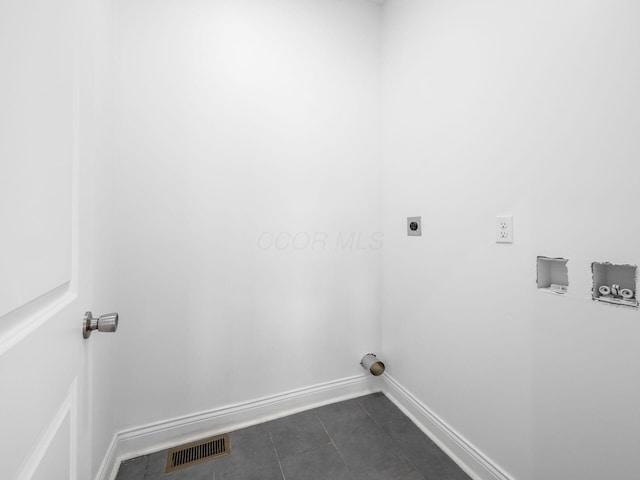 laundry room with dark tile patterned flooring, hookup for a washing machine, and electric dryer hookup