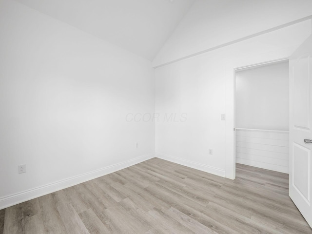 empty room with lofted ceiling and light wood-type flooring