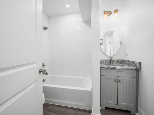 full bathroom with vanity, tiled shower / bath combo, wood-type flooring, and toilet