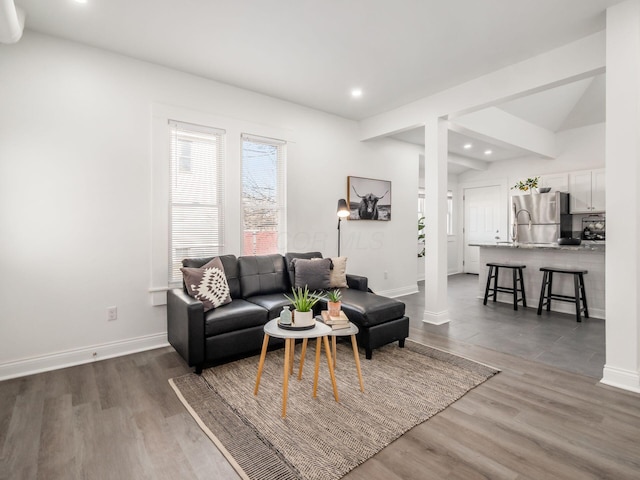 living room with dark hardwood / wood-style flooring and decorative columns