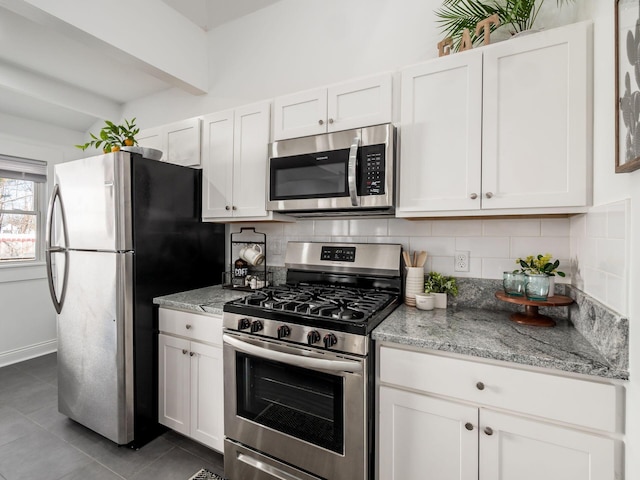 kitchen featuring white cabinetry, stainless steel appliances, light stone countertops, and tasteful backsplash