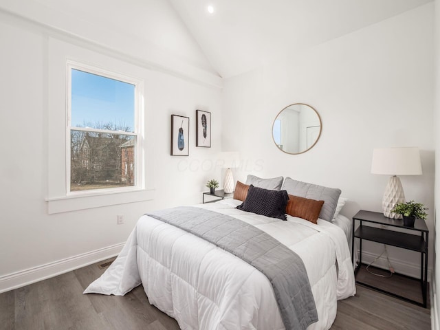 bedroom with hardwood / wood-style flooring and lofted ceiling