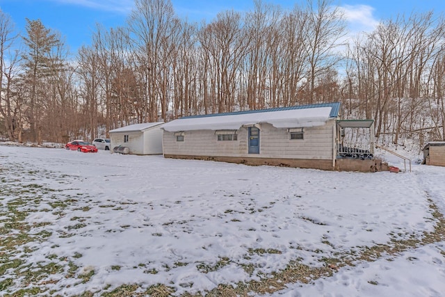 view of snow covered back of property