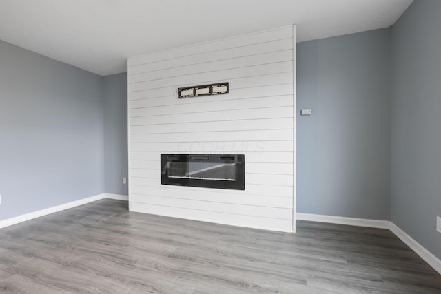 unfurnished living room with hardwood / wood-style flooring and a large fireplace